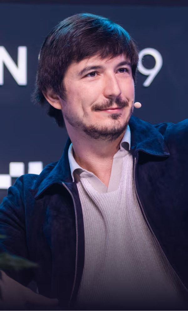 Speaker presenting at TOKEN2049 conference in Singapore with blue stage backdrop